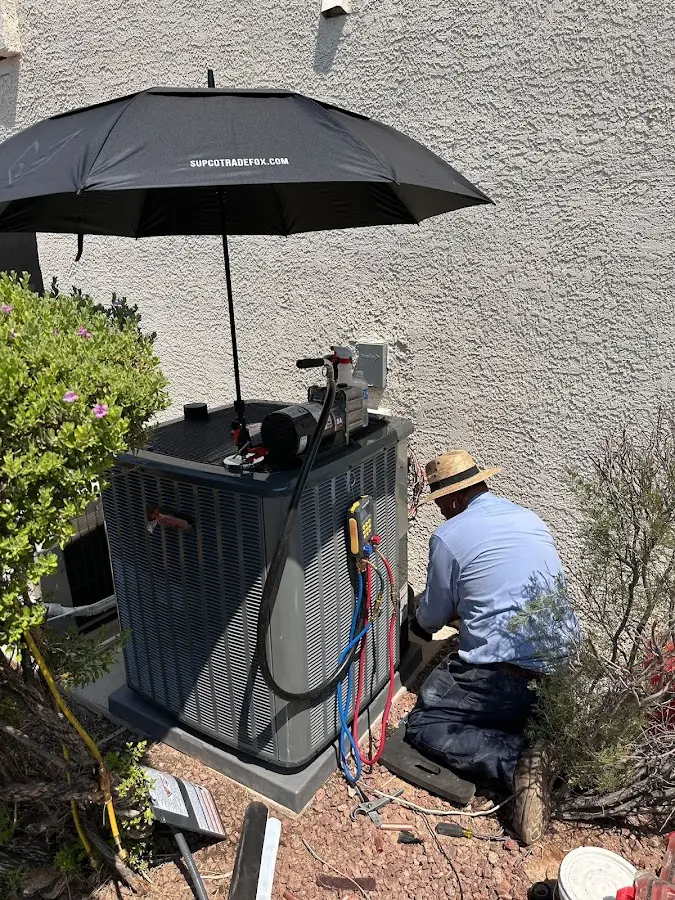 HVAC technician performing outdoor AC maintenance in Fox Point
